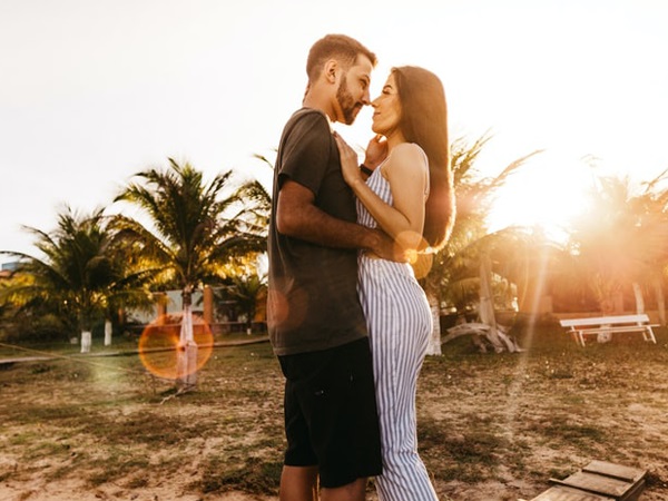 A photo of a man and woman hugging each other at the beach