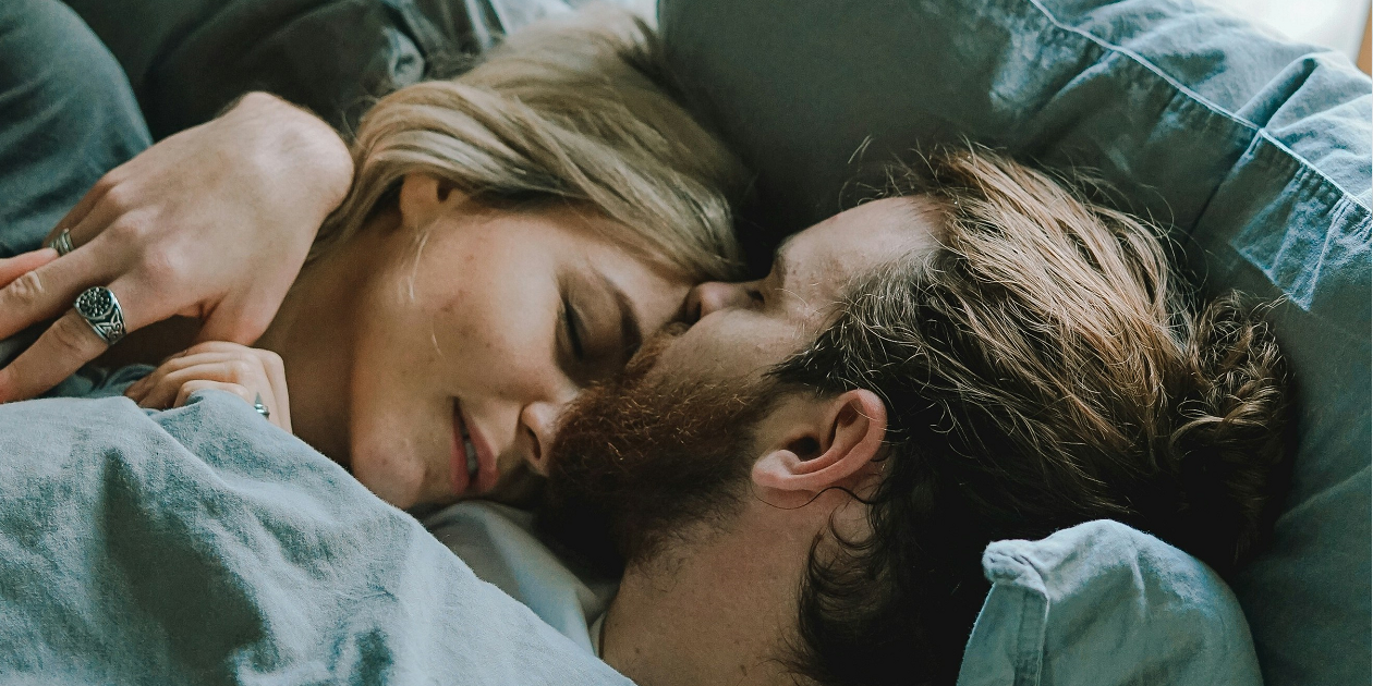 A couple showing up for each other and cuddling in bed.